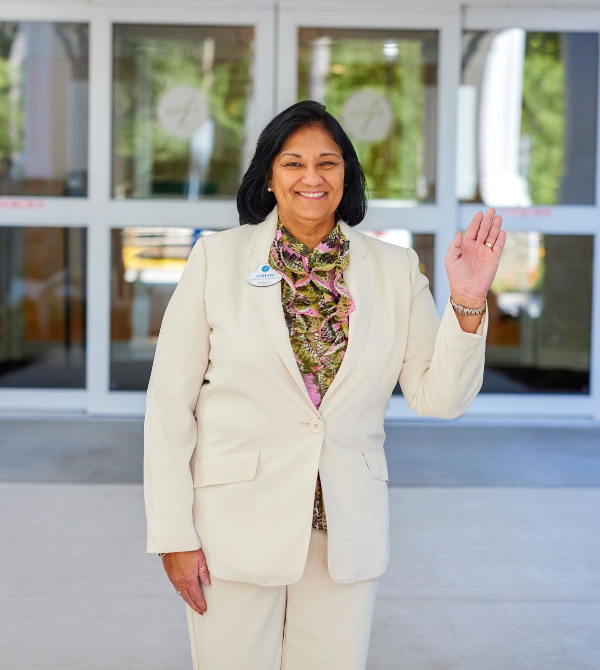Executive director stands in front of an Arbor community waving