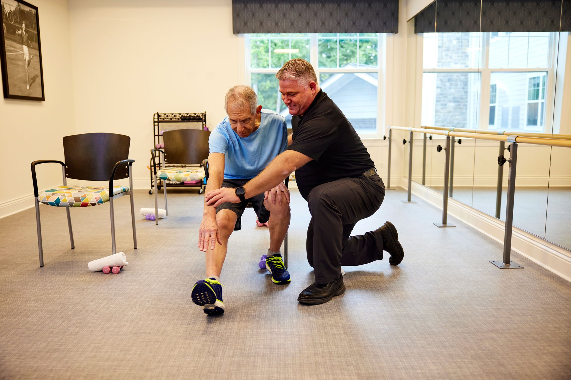 Member of the Arbor engagement team is helping a resident stretch
