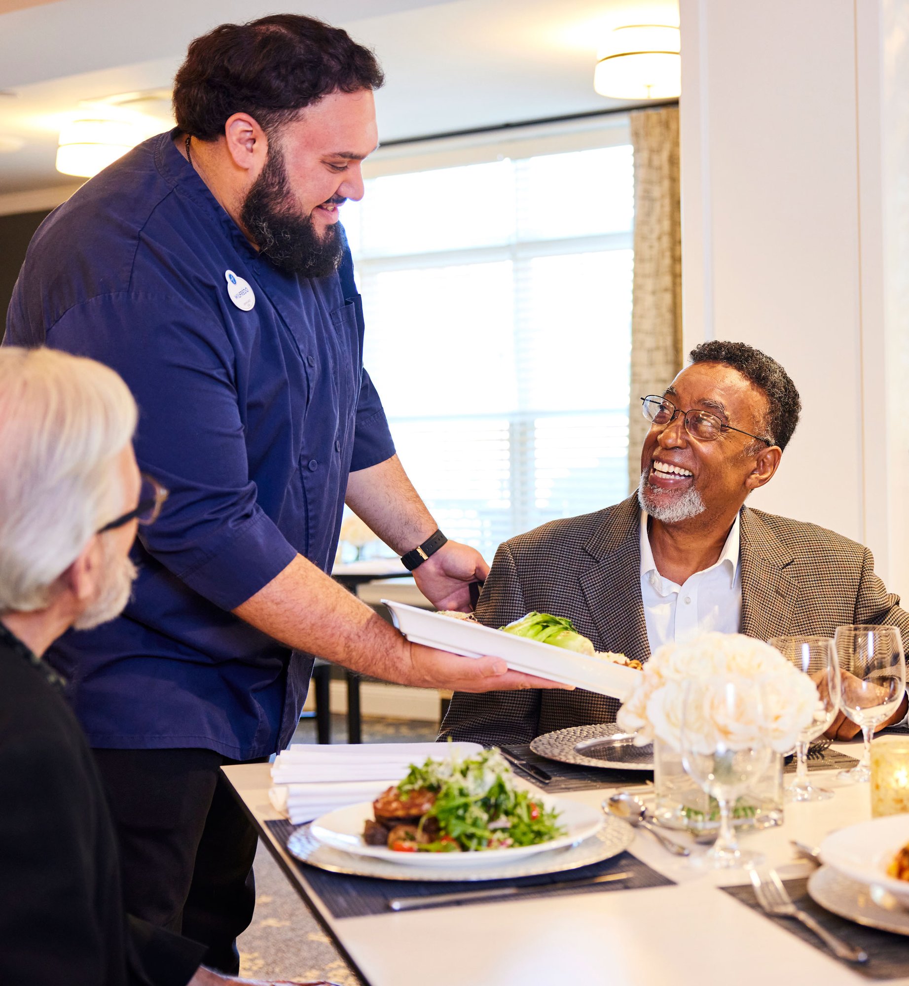 Dining manager serving a resident in the dining room