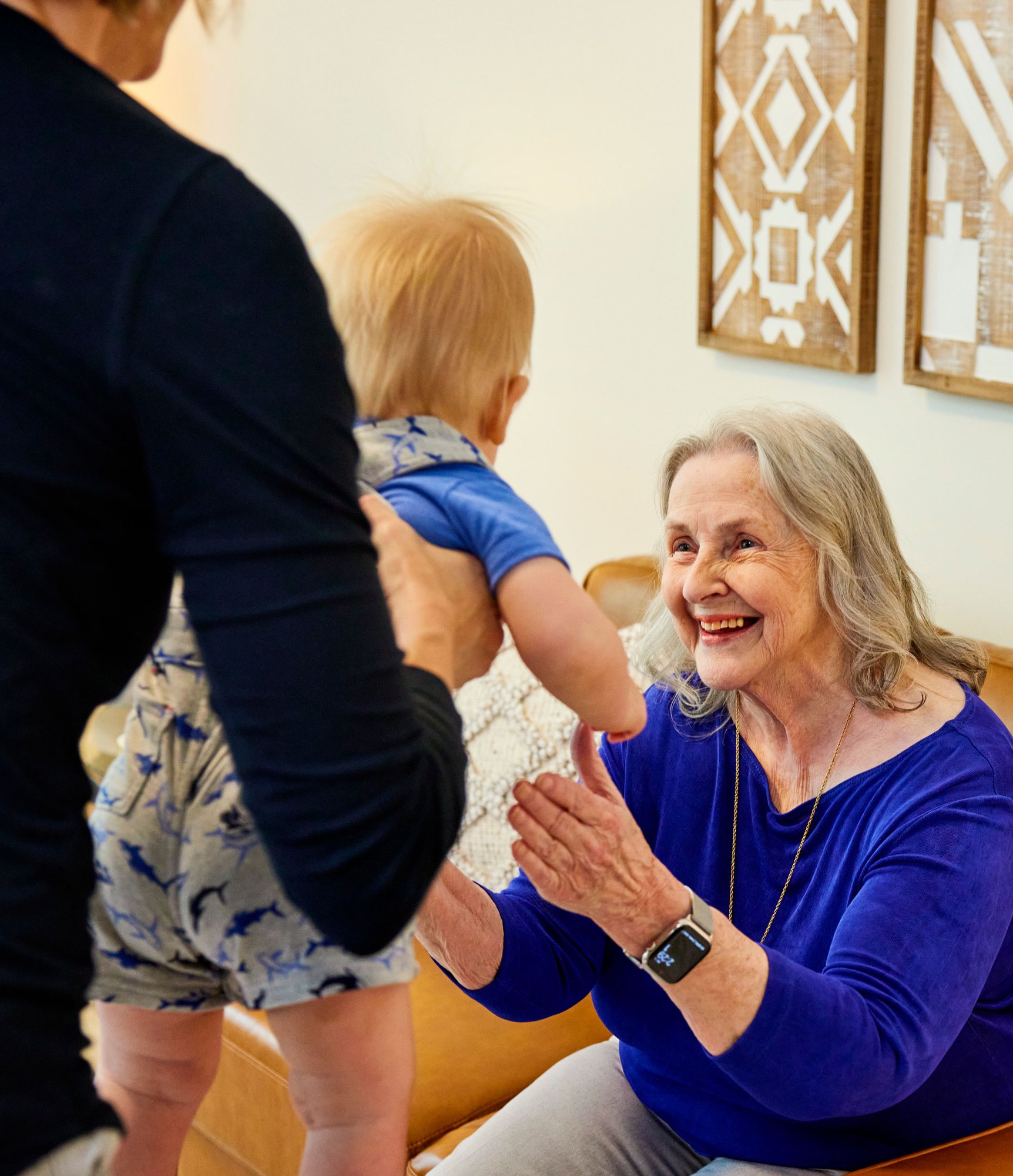 Family member handing a baby to a happy resident