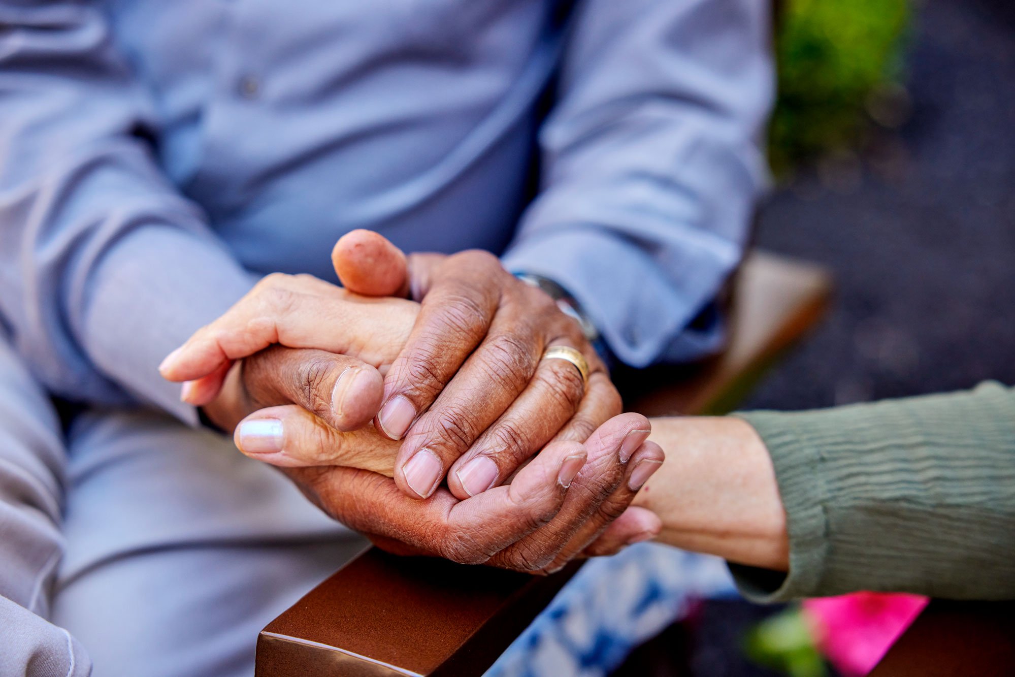Close-up of a caregiver and resident holding hands