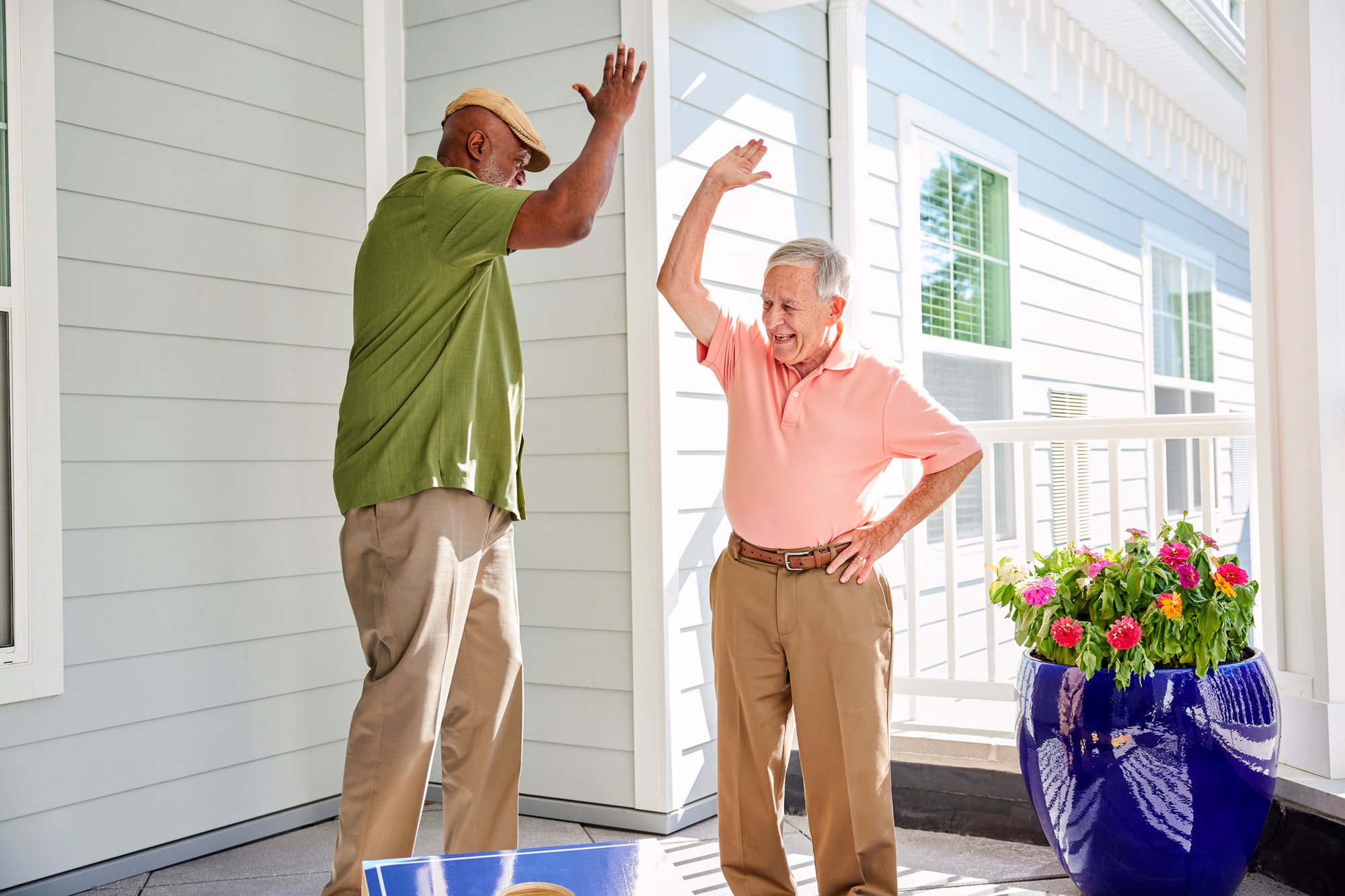 Two male senior residents giving each other a high-five
