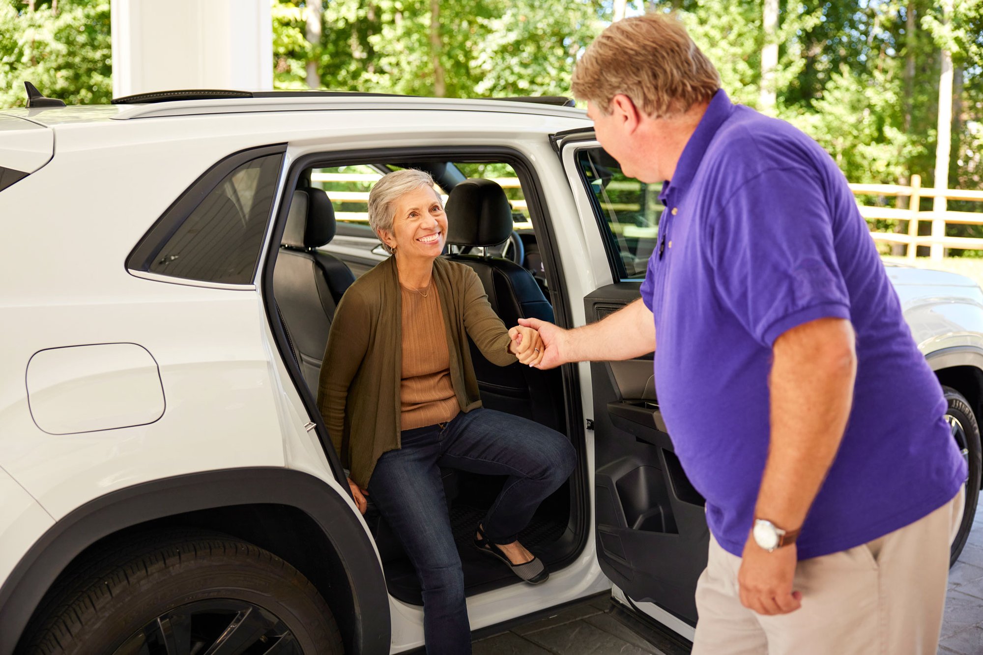 Member of the Arbor Administration department helping a resident out of a car