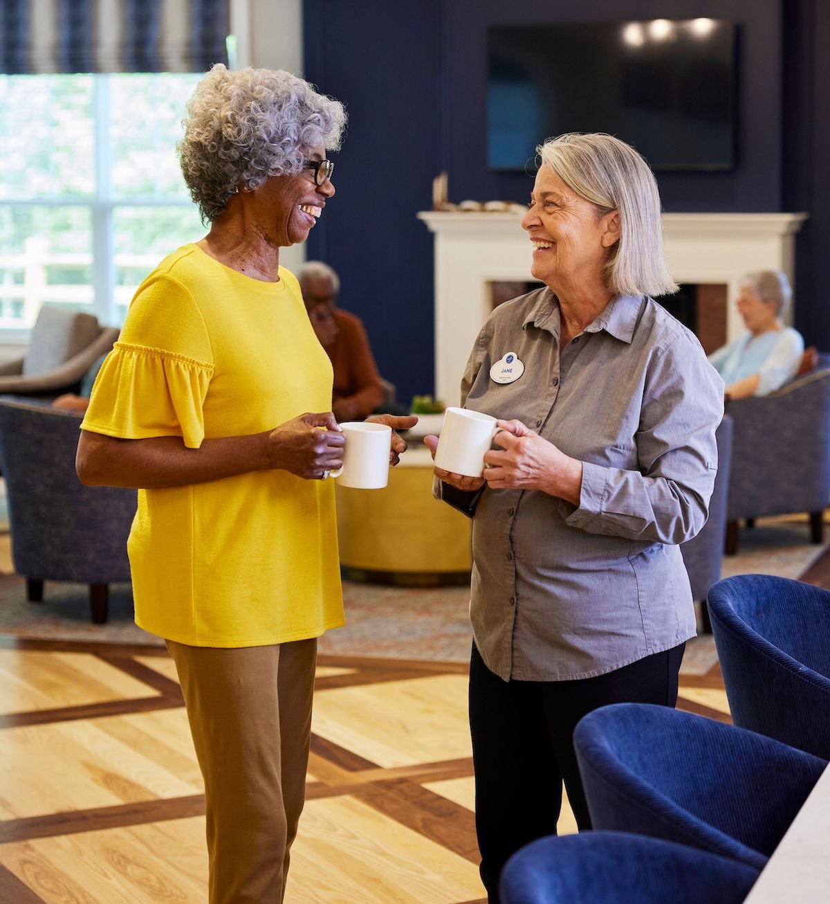 team member and resident with coffee in bistro