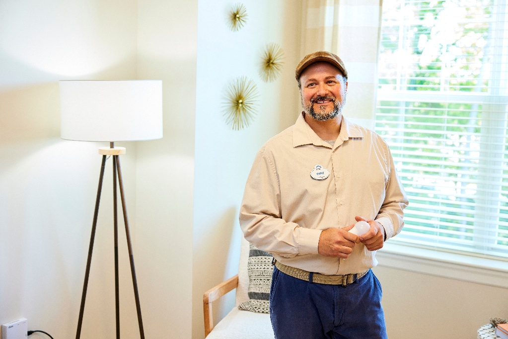 Arbor maintenance worker smiles before changing a lightbulb