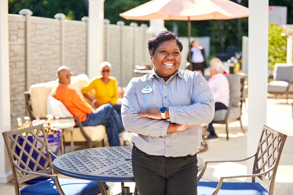 Arbor team member smiling while standing on a community patio